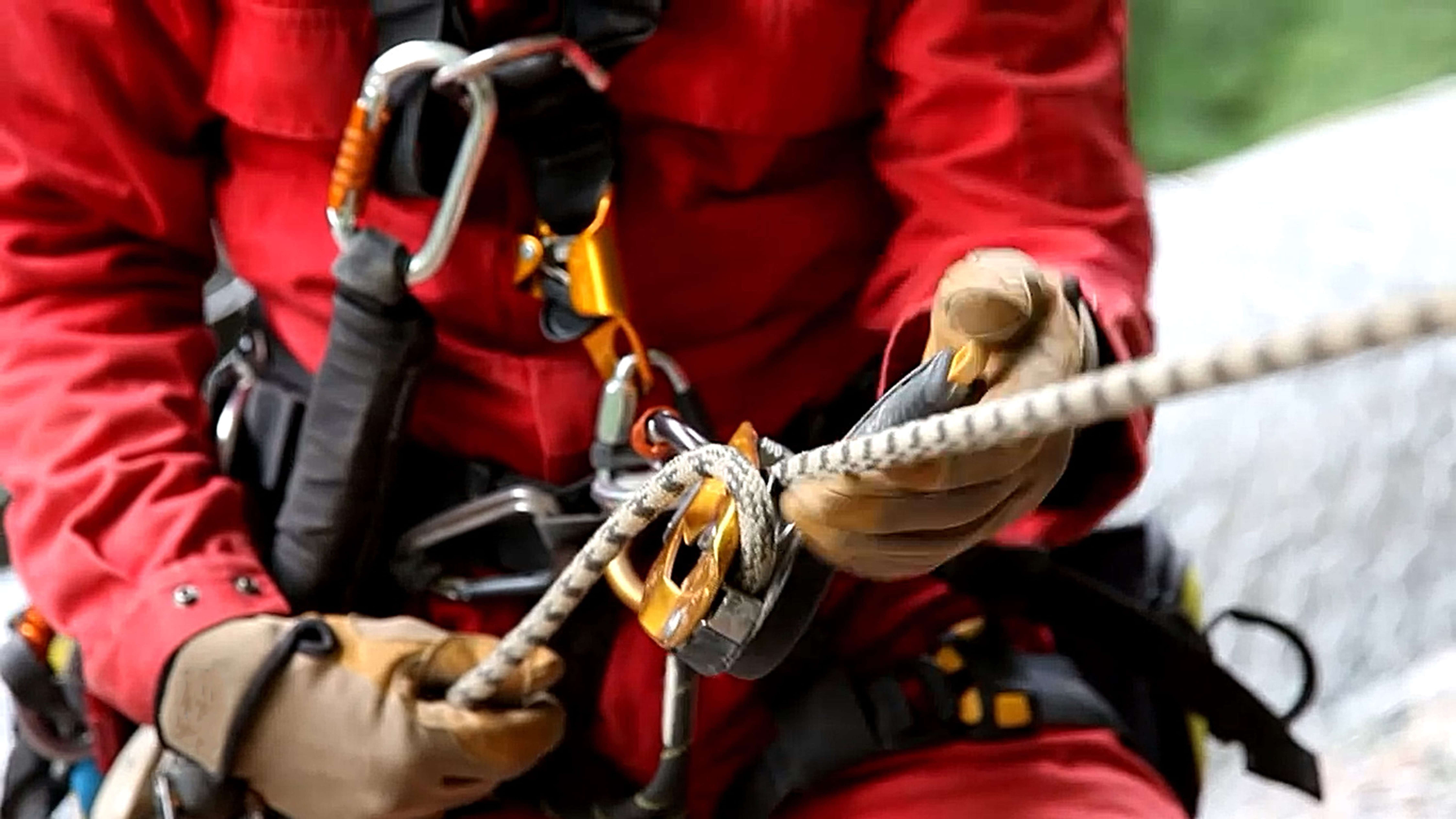 Rope access technician with harness and safety equipment