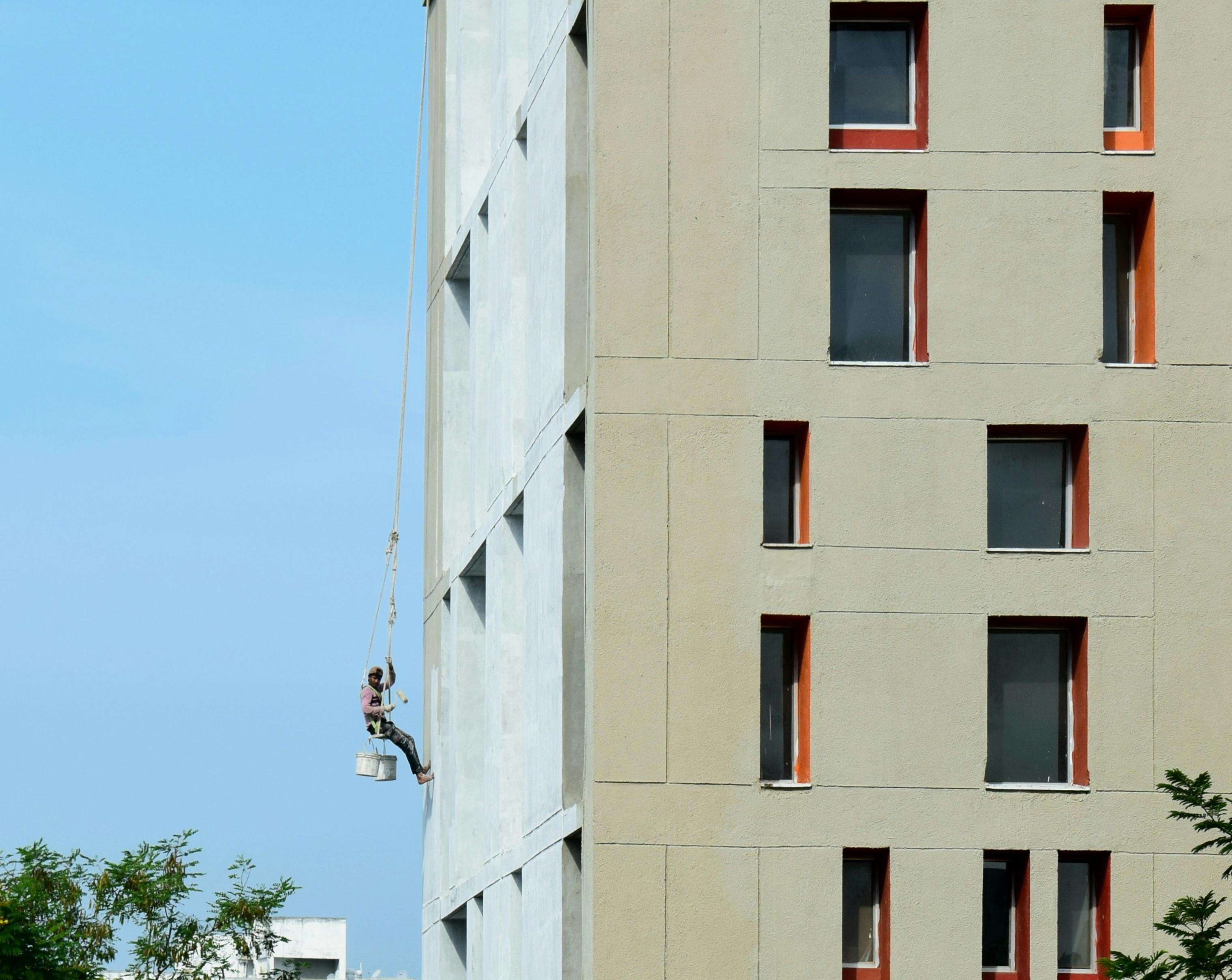 Rope access painter suspended on a building facade