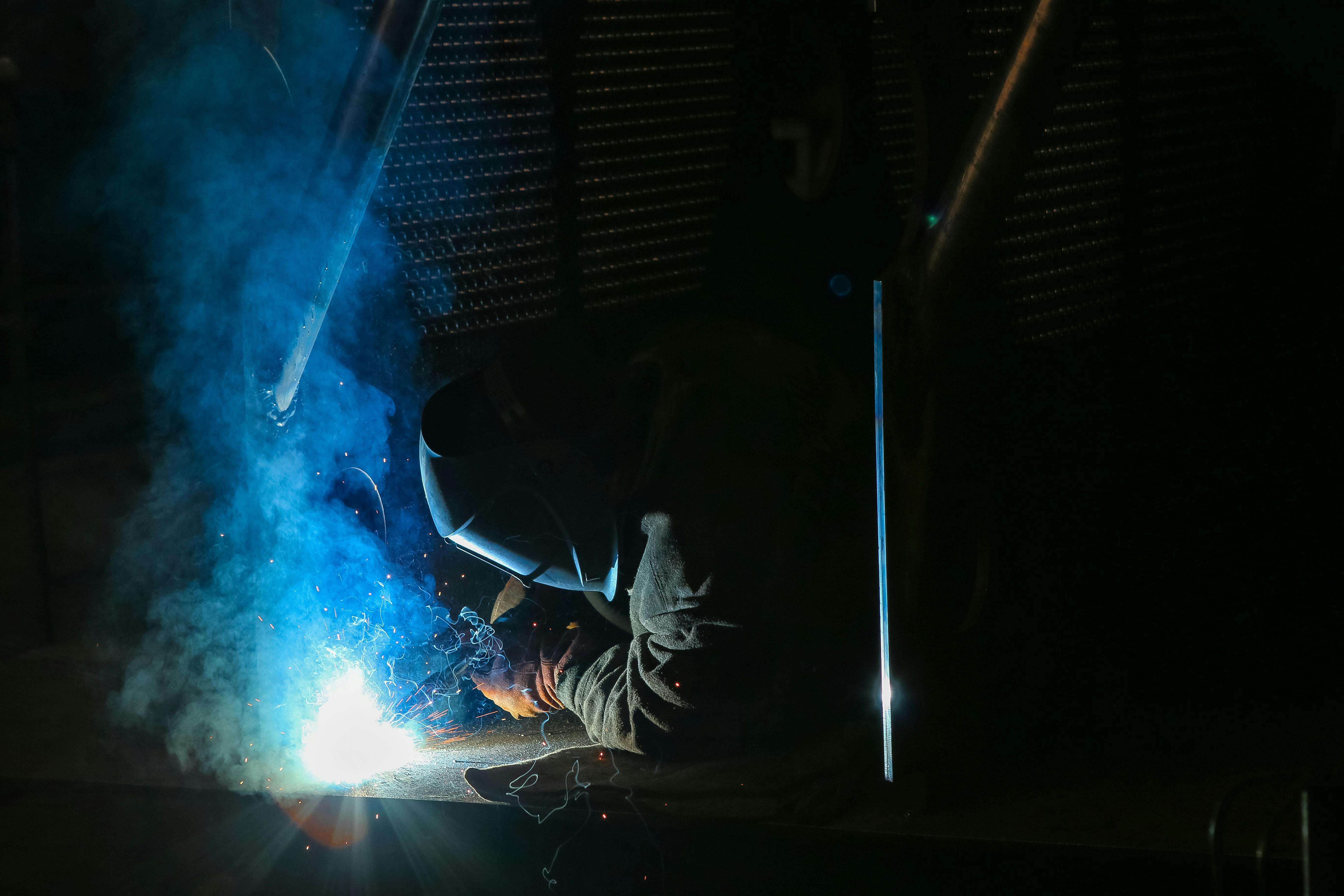 Welder creating bright sparks during industrial metalwork
